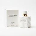 Valentino perfume bottle and packaging on a marble surface with a dark background